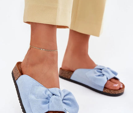 Sandales décontractées et élégantes inspirées du Brésil, en tissu bleu avec un nœud décoratif, semelle légère en liège et caoutchouc, idéales pour la plage ou les sorties urbaines, illustrant un style tropical et chaleureux.