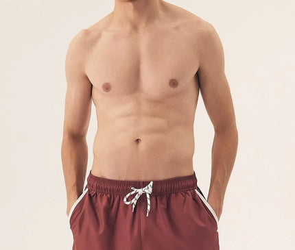 Short de bain pour homme couleur bordeaux à taille élastique avec cordon blanc, inspiré de l’énergie décontractée et vibrante du littoral brésilien. Coupe courte, détails modernes et esprit estival, parfait pour la plage ou les journées chaudes d'été.