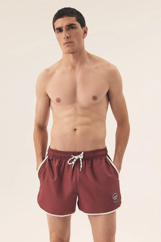 Short de bain pour homme couleur bordeaux à taille élastique avec cordon blanc, inspiré de l’énergie décontractée et vibrante du littoral brésilien. Coupe courte, détails modernes et esprit estival, parfait pour la plage ou les journées chaudes d'été.