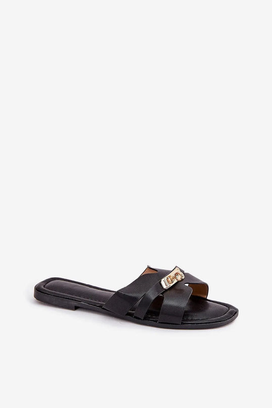 Sandales noires minimalistes inspirées du style brésilien, avec des lanières entrecroisées et un détail doré raffiné, parfaites pour un look décontracté et élégant, idéales pour la plage ou les rues animées de Rio.