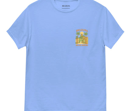 T-shirt bleu à manches courtes avec un design inspiré de Rio de Janeiro, représentant des palmiers, des bâtiments typiques et l'inscription 'Brazilina Rio de Janeiro'. Style tropical et décontracté évoquant l'énergie et la chaleur brésilienne.