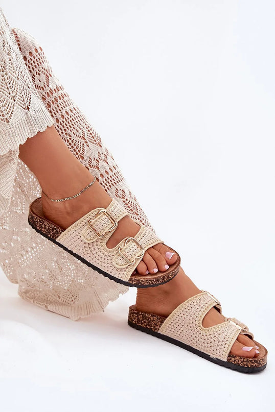 Sandales tissées beige avec boucles dorées, inspirées du savoir-faire artisanal brésilien, combinant crochet et matières naturelles, idéales pour un style bohème décontracté. Repose sur une semelle en liège pour un confort optimal, parfait pour l'été ou la plage.