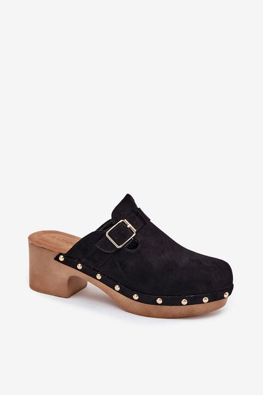 Sabots pour femmes en suédine écologique de couleur noire avec boucle dorée et clous décoratifs sur la semelle. Montés sur un talon bloc de 6 cm, ces chaussures offrent un style élégant et une touche de caractère rock, avec une semelle intérieure souple pour un confort optimal.