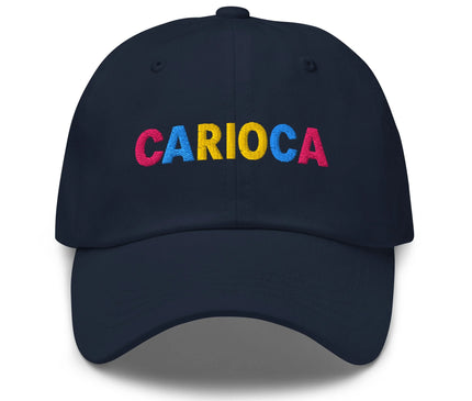 Casquette bleu marine avec le mot 'Carioca' brodé en lettres colorées (rose, jaune et bleu) sur le devant. Accessoire inspiré par la culture vibrante de Rio de Janeiro, mettant en avant l'esprit festif et chaleureux du Brésil. Parfaite pour un style décontracté et contemporain célébrant la richesse culturelle carioca.