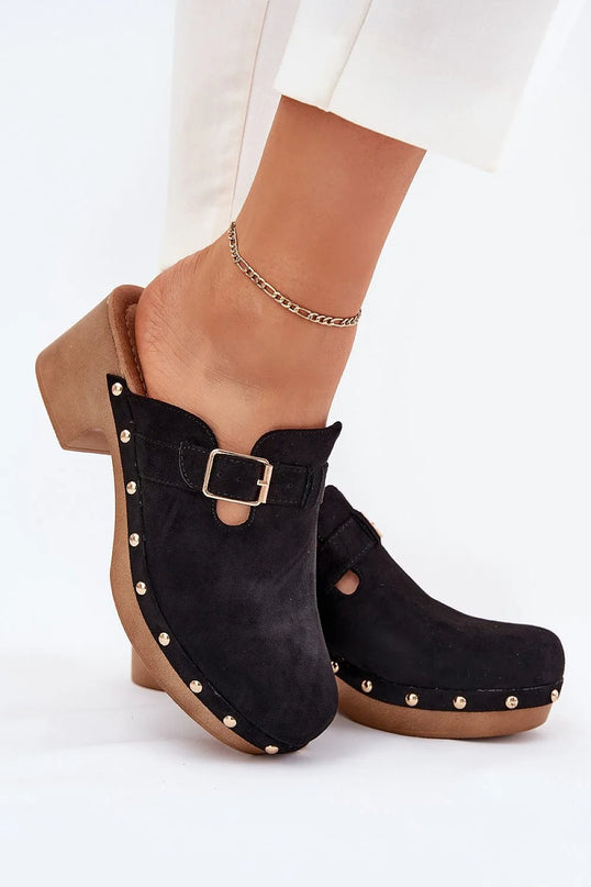 Sabots pour femmes en suédine écologique avec talon bloc de 6 cm, sangle élégante avec boucle dorée, clous métalliques décoratifs sur la semelle pour une touche rock, et semelle intérieure souple pour un confort quotidien. Modèle noir idéal pour les tenues décontractées ou élégantes.