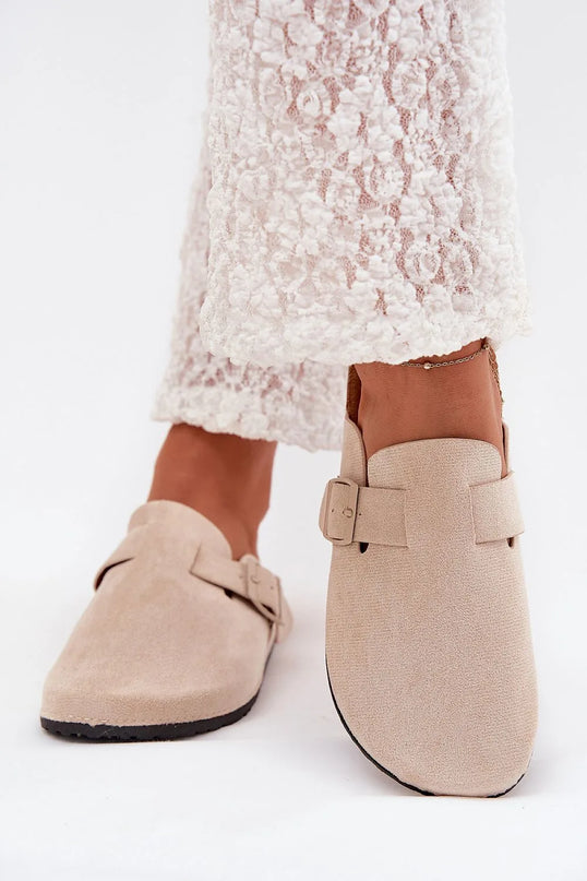 Claquettes pour femmes avec semelle en liège et en suédine écologique beige. Design avec bouts fermés, boucle ajustable pour un maintien parfait, et semelle profilée de 2,5 cm offrant confort toute la journée. Parfaites pour un style quotidien élégant et confortable.