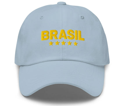 Casquette bleu clair avec l'inscription 'Brasil' en broderie jaune et cinq étoiles dorées en dessous, symbolisant les victoires légendaires du Brésil dans le football. Accessoire célébrant la culture brésilienne, mélange de fierté nationale, de joie de vivre et d'élégance décontractée.
