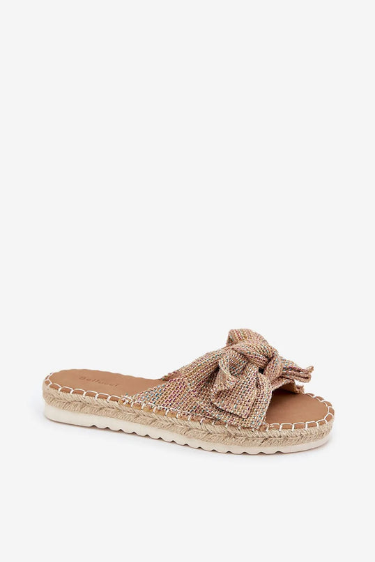 Sandales plates brésiliennes en matériaux naturels avec une confection artisanale tressée, ornées d'un élégant nœud sur le dessus, évoquant un style décontracté et chaleureux inspiré des plages et carnavals de Rio.