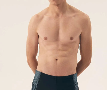 Homme portant un maillot de bain noir moderne et minimaliste, inspiré de l'élégance décontractée des plages brésiliennes comme Copacabana et Ipanema. Le design inclut des détails graphiques sur les côtés, incarnant l'esprit vibrant et énergique du Brésil. Idéal pour allier confort et style sur la plage.