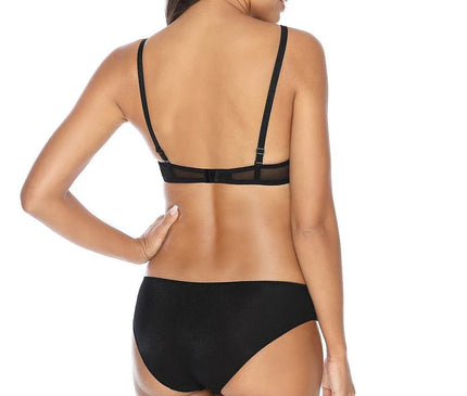 Vue arrière d'une femme portant une culotte noire, mettant en valeur le design élégant et confortable du modèle Phenomenal Jackie, conçu en tricot extensible à l'arrière avec un gousset en coton, idéal pour un mélange de confort et d'élégance.