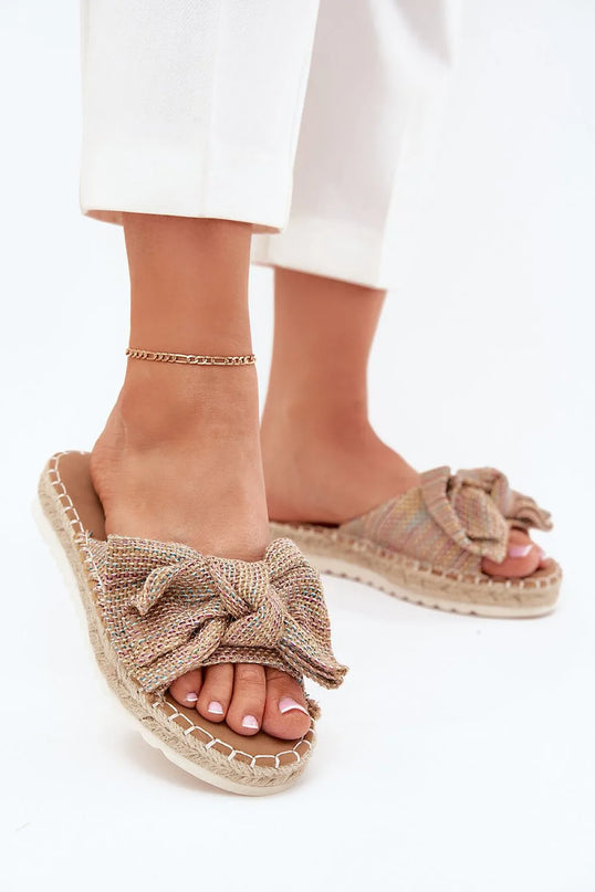 Sandales décontractées et élégantes inspirées de la mode brésilienne, confectionnées avec des matériaux naturels tressés, caractérisées par un nœud décoratif et une semelle en corde, idéales pour un style estival, festif et authentique.