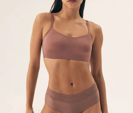 Sous-vêtement féminin d'inspiration brésilienne dans des tons naturels, composé d'un haut brassière simple et raffiné, et d'une culotte avec bordure en dentelle subtile. Design moderne alliant confort, liberté de mouvement et esthétique tropicale élégante.