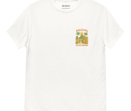 T-shirt blanc avec un design inspiré de Rio de Janeiro, représentant des palmiers et des bâtiments caractérisés par l’architecture brésilienne. Illustration évoquant les paysages tropicaux et l’ambiance festive du Brésil, avec le texte 'Brazilina - Rio de Janeiro' inscrit. Idéal pour un style décontracté et exotique.